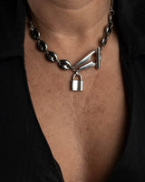 Stainless steel choker necklace featuring a chunky anchor link chain and a padlock charm, worn close to the neckline.