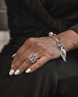 Boho silver spiral statement ring on a hand, showcasing its adjustable geometric design with bold, intricate spirals.