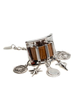 Chunky silver cuff bracelet featuring khaki-brown snake leather and five dangling silver charms. Adjustable design.