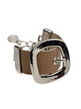 Textured beige leather wide cuff bracelet with a prominent silver buckle and adjustable clasp. Sophisticated and bold design.