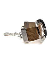 Chunky beige leather cuff bracelet featuring a prominent silver buckle and textured finish, adjustable with an extension chain.