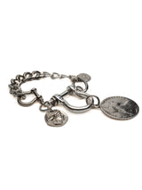 Silver-plated chunky bracelet with large ancient coin pendants and industrial U-lock clasp.