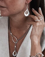 Bold open teardrop earrings in antique silver finish, worn by a model, showcasing a stylish, edgy design.