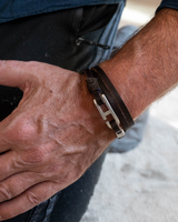 Brown leather wrap bracelet for men with a zamak buckle, layered around the wrist, showcasing its minimalist design.