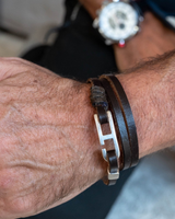 Brown leather wrap bracelet for men featuring a zamak buckle, securely wrapped around the wrist, exuding a minimalist style.