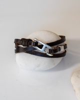Brown leather wrap bracelet for men featuring a silver zamak buckle, securely fastened with three winding bands.