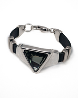 Black leather bracelet featuring a large triangular grey-black Austrian crystal, secured with silver-colored metal accents.