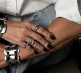 Minimalist 925 Sterling Silver unisex ring in gold plating, worn alongside multiple rings and a chunky bracelet.