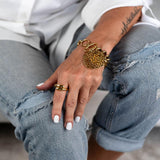 Adjustable minimalist 925 Sterling Silver ring with gold plating, worn on the index finger, paired with a chunky bracelet.
