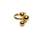 Gold triple ball ring featuring three shiny spheres on a twisted adjustable band, showcasing a modern and edgy design.