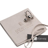 Chunky silver triple ball ring on a suede pouch, featuring a stylish wrap-around design with large spherical accents.