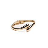 Chunky gold metal cuff bracelet with a sleek, minimal design featuring a curved shape and high-polished finish.