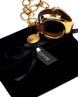 Gold triple wrap bracelet featuring beige leather, stainless steel chain, and a unique metal hoop. Comes in a black suede pouch.