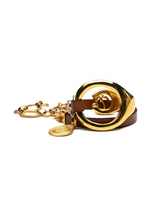 Gold triple wrap bracelet featuring light brown leather, stainless steel chain, and a large metal hoop detail.