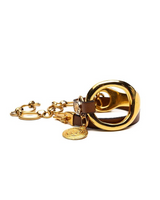 Gold triple wrap bracelet featuring beige leather and a stainless steel chain, with a large metal hoop design.