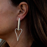 Asymmetric stainless steel heart earrings, featuring a long heart and a shorter design, worn elegantly on the ear.