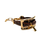Chunky bracelet featuring a large gold metal plate and soft brown leather strips, adjustable with an extension chain.