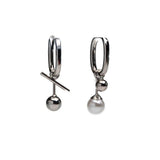 Asymmetrical drop earrings featuring a pearl on one and a sleek metal ball on the other, with a modern U shape design.