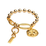 Chic gold bracelet featuring a ball chain and a Greek coin charm, showcasing a bright, shiny finish.