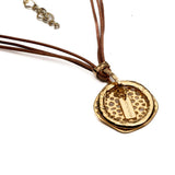Leather hoop statement necklace with multiple natural leather strands and hammered gold-plated asymmetrical pendant