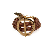 Chunky golden hoop and bar bracelet with multiple natural leather strands, featuring a hammered texture and adjustable fit.