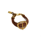 Chunky golden hoop bracelet with hammered bar, featuring multiple natural leather strands and an adjustable clasp.