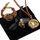 Chunky hammered gold hoop bracelet features natural leather strands and a toggle clasp, presented on a black suede pouch.