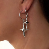 Silver star-shaped earrings worn by a person