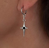 Silver hoop earring featuring a dangle cross with a black enamel charm, worn on a model's ear.