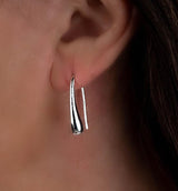 High polished silver teardrop earrings, approximately 2 inches long, hanging elegantly from the earlobe.