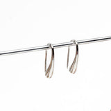 High polished silver teardrop earrings, approximately 2.0 inches long, displayed on a bar.