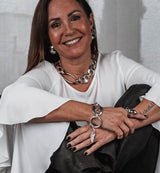 Oversized polished metallic dome stud earrings, 4 cm round, paired with layered silver jewelry and a white top.