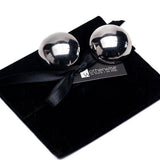 Oversized dome stud earrings in polished metallic finish, 4 cm round, resting in an elegant black suede pouch.