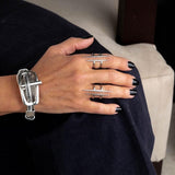 Stainless steel double bar ring featuring irregular bars, worn on a hand with black nails alongside a bracelet.