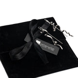Asymmetrical earrings in silver with an irregular abstract design displayed on a black suede pouch with a ribbon.