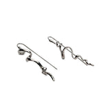 Mismatched asymmetrical earrings in silver featuring an abstract irregular design with hanging elements.