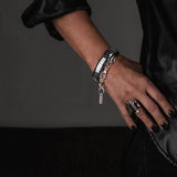 Multi-strand rock-style bracelet featuring polished hematite beads and sleek chain accents, worn on a model's wrist.