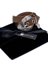 Double-wrap bracelet in genuine khaki leather with a large silver western-style buckle, presented on a black pouch.