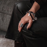 Chunky Chain Bracelet with Vintage Coins, featuring silver-plated links and a leather closure, worn on a hand with dark nails.
