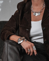 Western Buckle Leather Wrap bracelet in khaki leather worn on the wrist, featuring a large silver-plated buckle for an edgy look.
