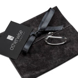 Irregular sterling silver plated two-finger ring resting on a textured black suede pouch with a ribbon.