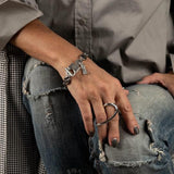 Sterling silver plated two-finger ring wraps around fingers, featuring a geometric, edgy design with graceful curves.