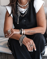 Chunky silver ball chain choker worn as a statement necklace, layered with other bold metal jewelry.