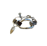 Edgy metal and leather bracelet with irregular silver design and brown leather accents. Adjustable with extension chain.