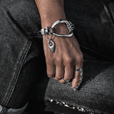 Standout metal and leather bracelet featuring a unique irregular silver design and black leather, presented on a model's wrist.