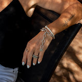 Stainless steel thick chain anklet/bracelet featuring oval links and connectors, worn stacked with other bracelets.