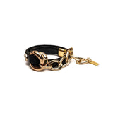 Chunky double link bracelet featuring black leather and honey gold metal accents, designed in an edgy style.
