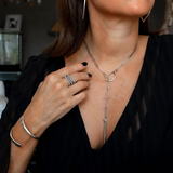 Woman wearing a silver necklace and bracelet with a blurred background