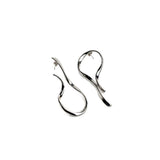 Large asymmetric dangle earrings with irregular lines and hammered stud tops, showcasing a sculptural silver-tone design.