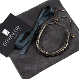 Adjustable bronze hematite bracelet with a segmented design, presented on a suede gift pouch with a black ribbon.